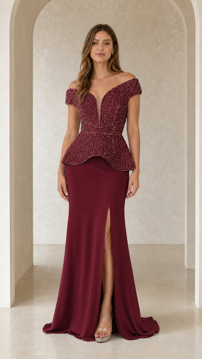 Model wearing burgundy red beaded peplum evening dress with high leg slit