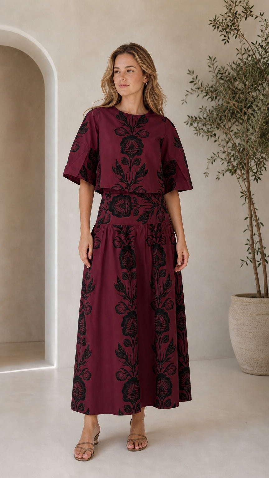Woman wearing burgundy floral print matching crop top and maxi skirt set