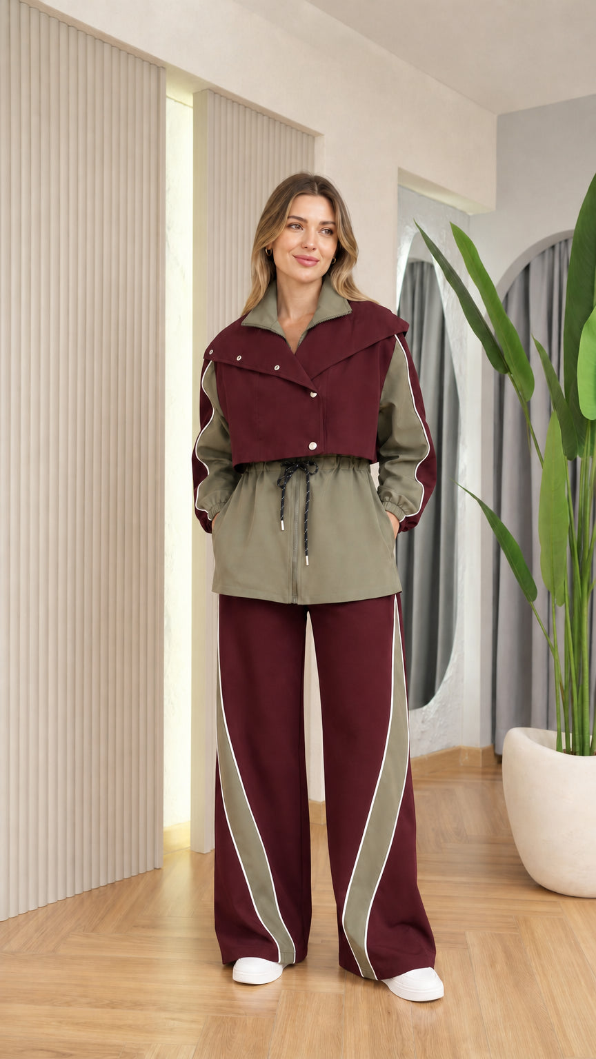 Front view of woman wearing burgundy and olive green colorblock track jacket and pants set