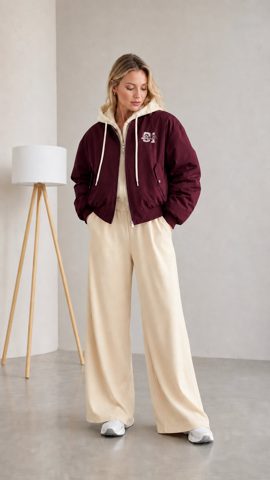 Woman wearing burgundy layered hooded bomber jacket