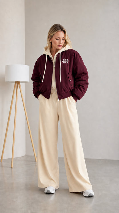 Woman wearing burgundy layered hooded bomber jacket