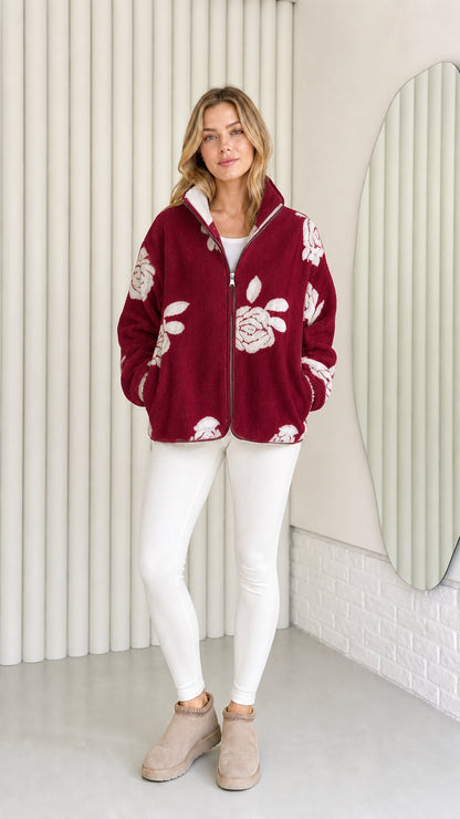 Model wearing burgundy fleece jacket with light floral pattern