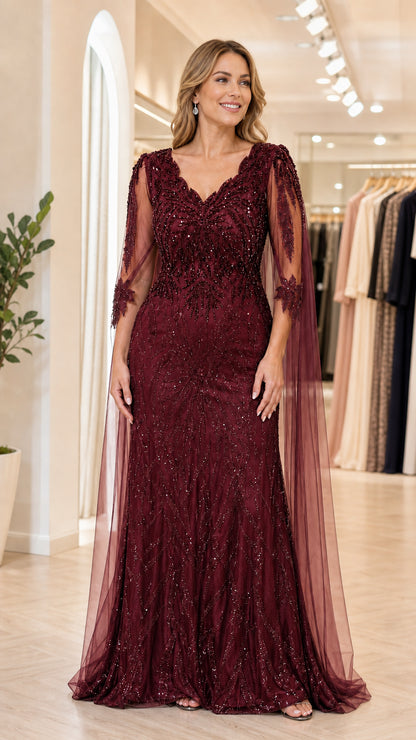 Front view of model wearing burgundy wine red sequin evening gown with cape overlay