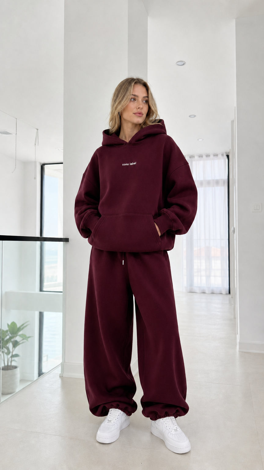 Full-length view of model wearing the burgundy oversized hoodie and sweatpants set