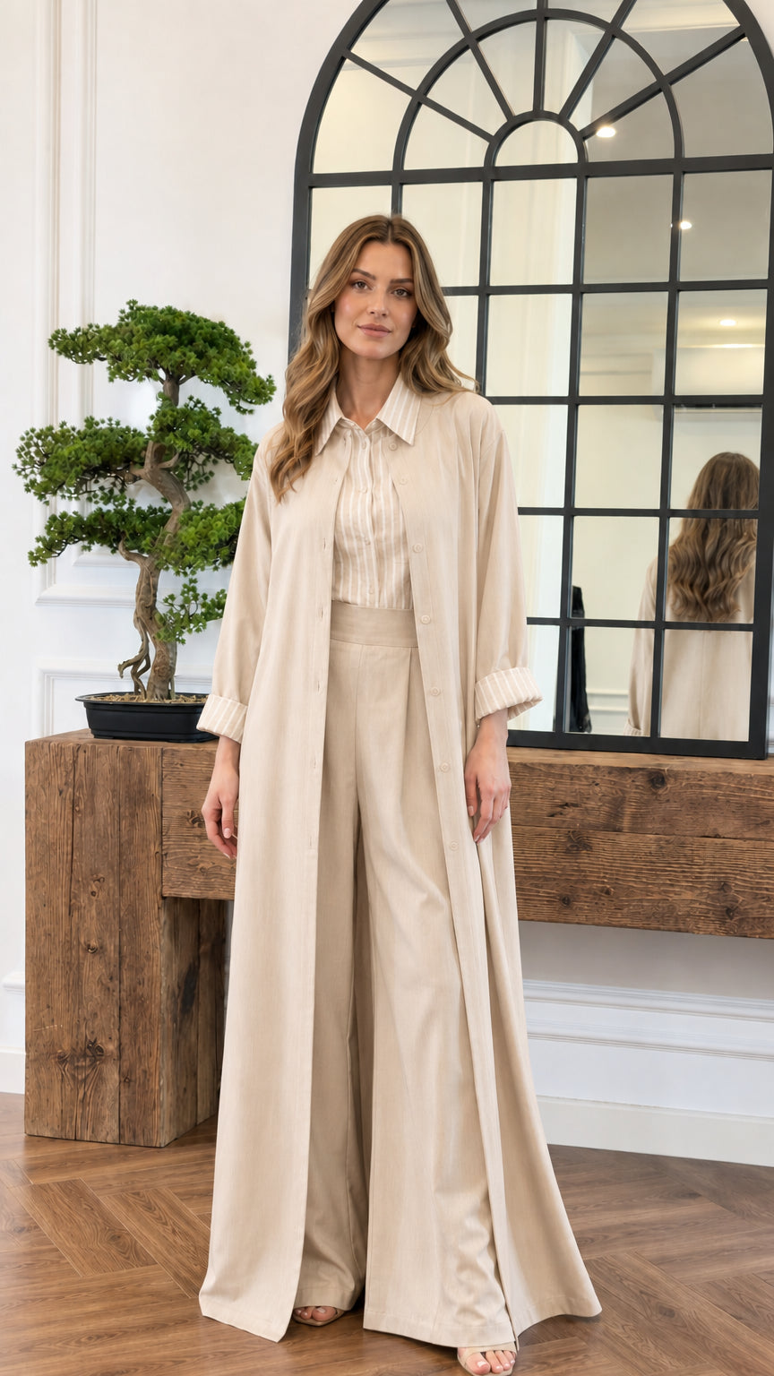 Model wearing the neutral beige 3-piece duster coat and matching trousers set