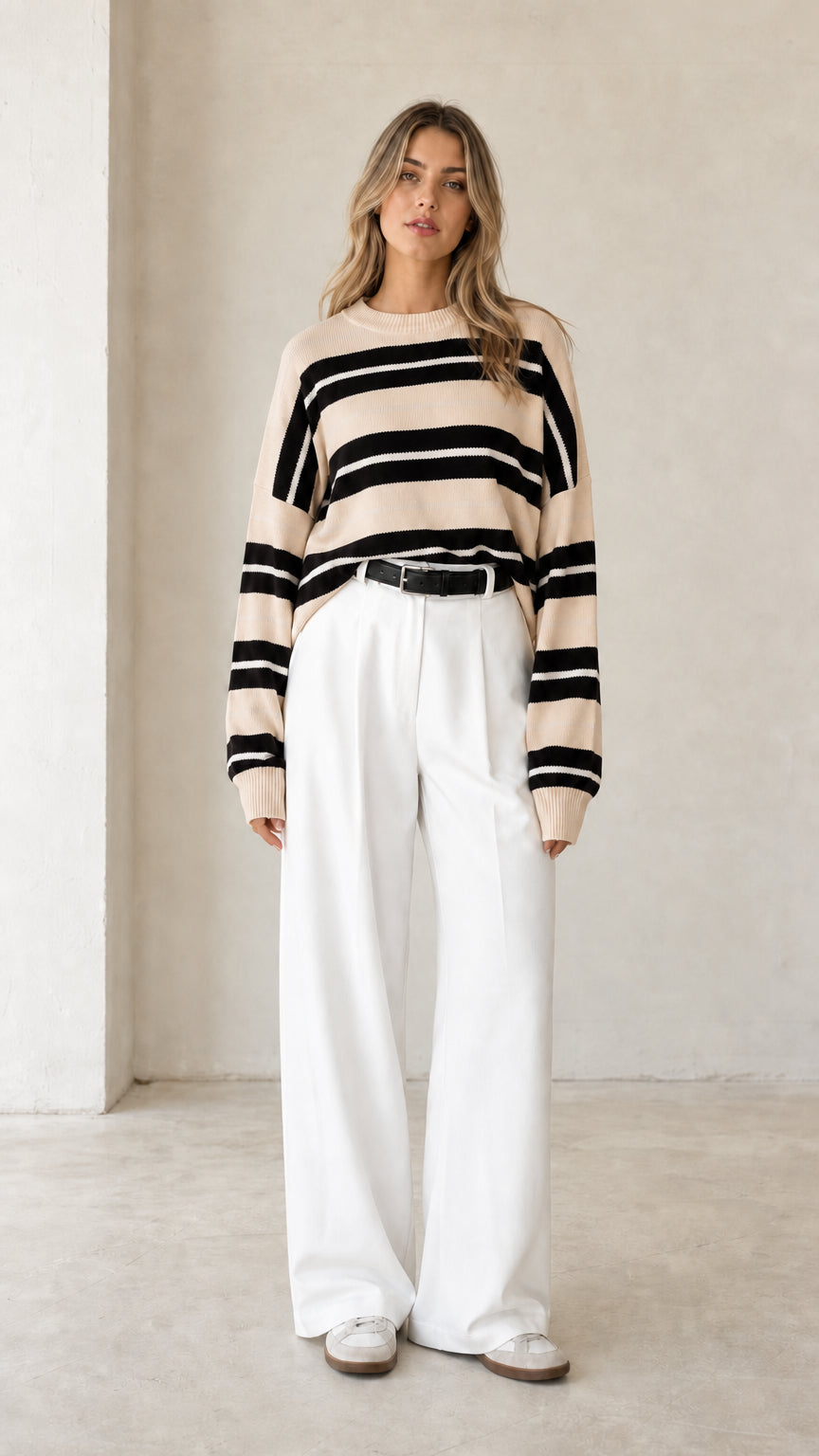Front view of woman wearing beige neutral striped crewneck knit sweater