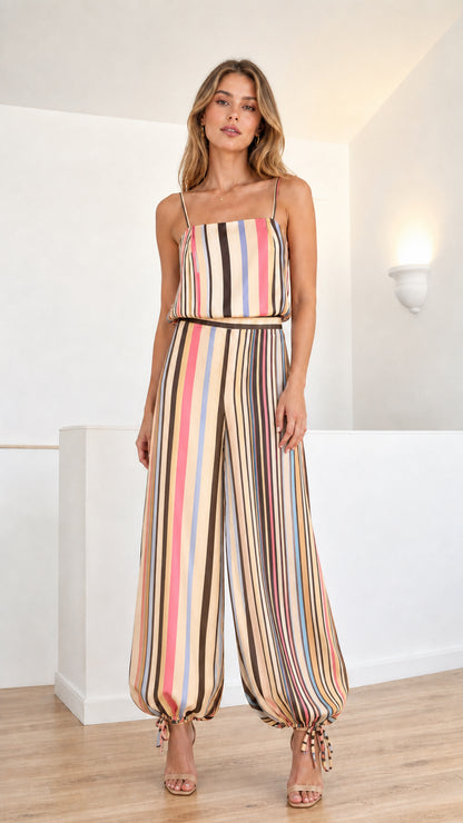 Model wearing neutral beige and brown multi-colored striped cami jumpsuit