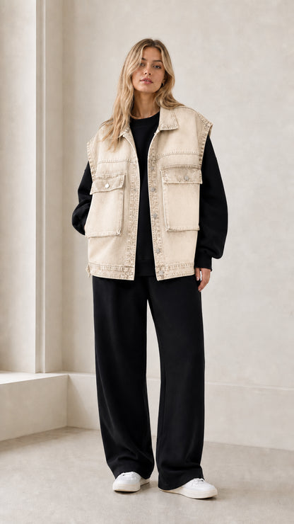 Front full view of woman wearing beige vintage washed oversized denim vest
