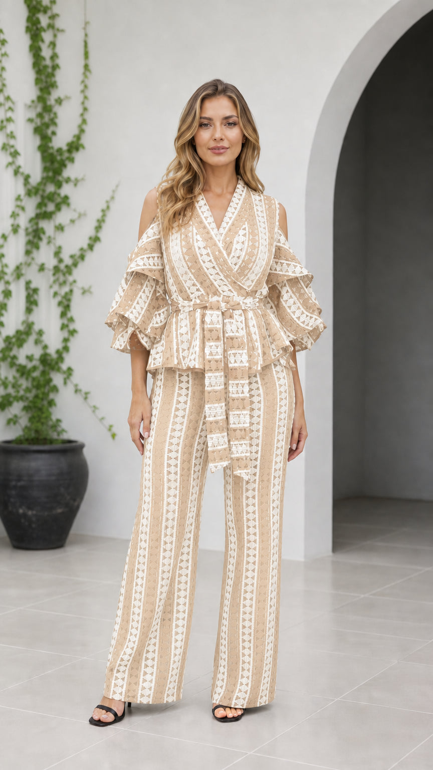 Front view of woman wearing beige tan geometric cold shoulder wide-leg jumpsuit