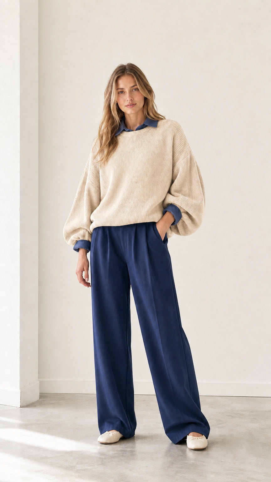 Model wearing beige oatmeal relaxed ribbed knit sweater with blue shirt trim
