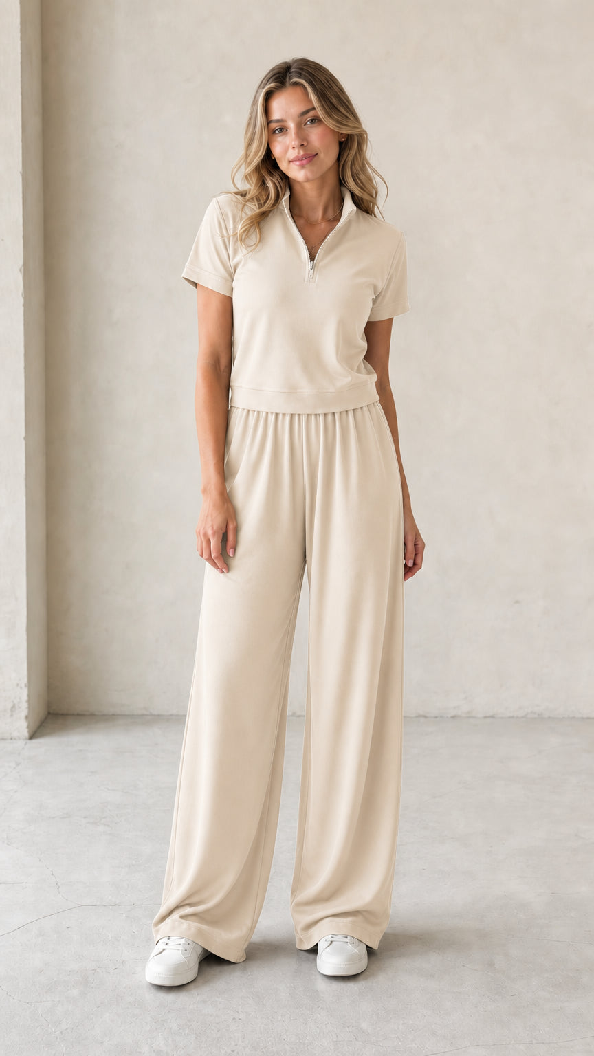 Front view of woman wearing beige cream half-zip short-sleeve top and wide-leg pants set