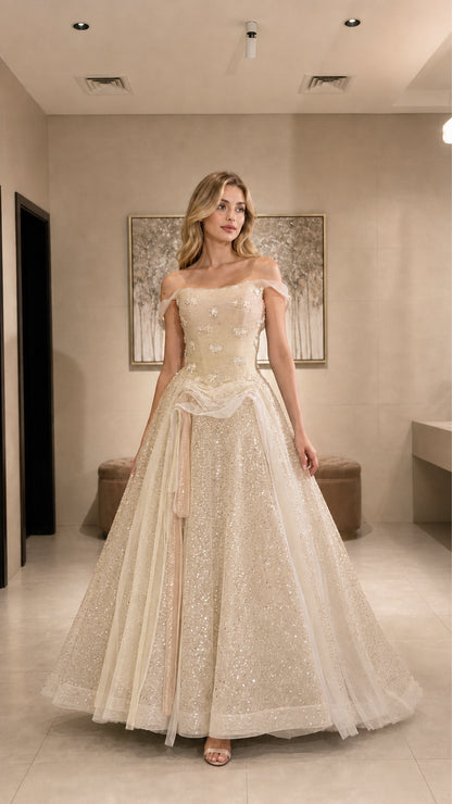 Model wearing champagne gold glitter tulle ball gown with off-the-shoulder straps
