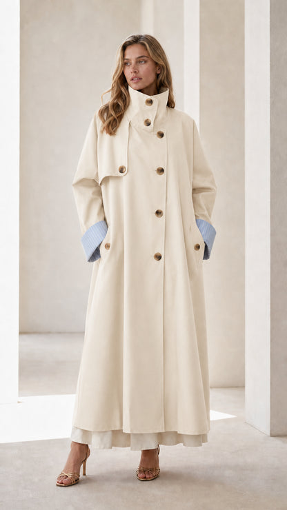 Full-body view of woman wearing an off-white long trench coat